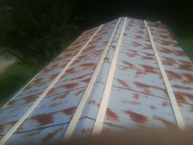 Rusted metal roof panels with new wood purlins before replacement — Storm Damage Roof Repair in Pine Mountain by Roofing Brothers