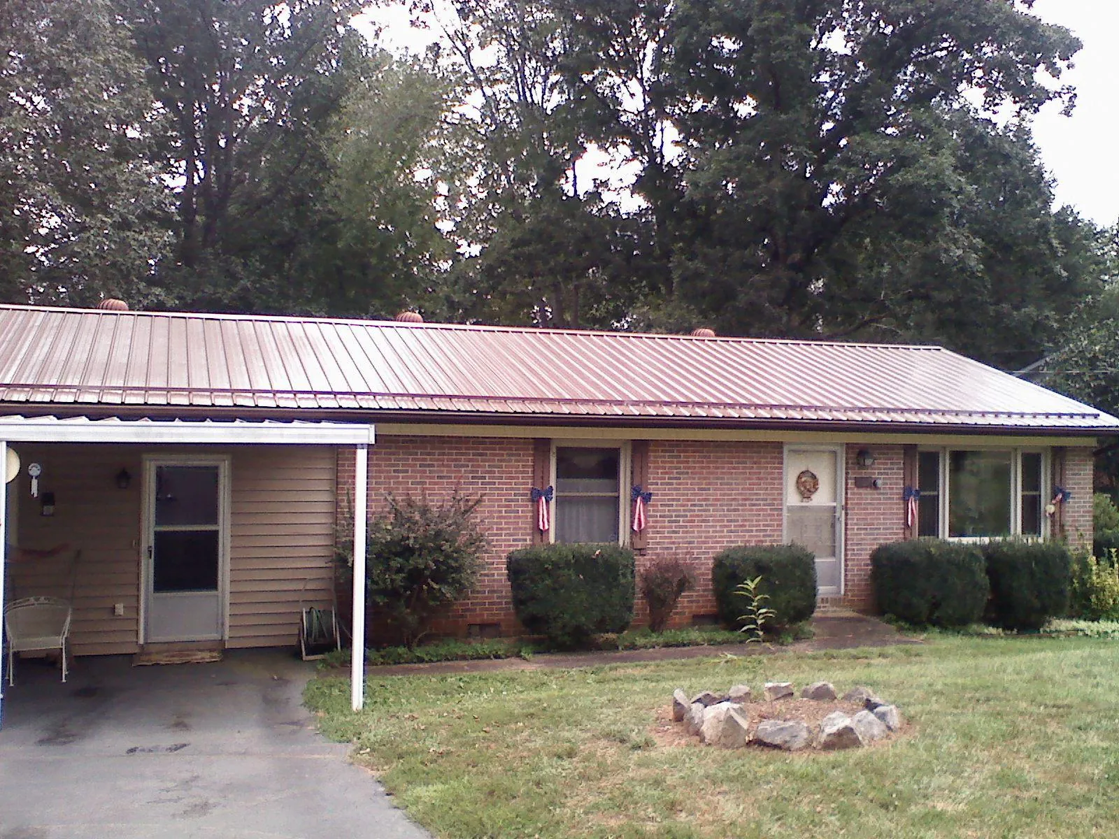 Bronze metal roof and carport on a brick ranch home — Roof Repair work by our crew in Pine Mountain